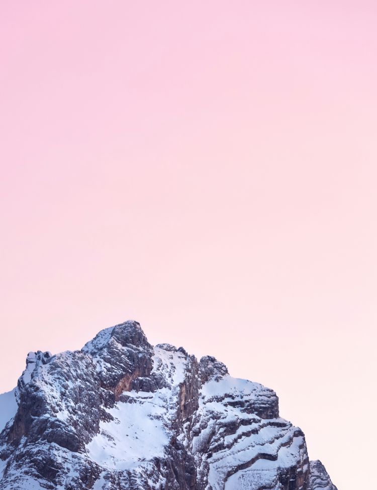 A snow coloured mountain in the Dolomites with a sunsetted hazy background.